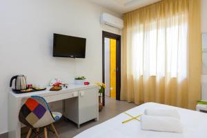 um quarto com uma secretária e uma televisão na parede em Miamò Suite em Castellammare di Stabia