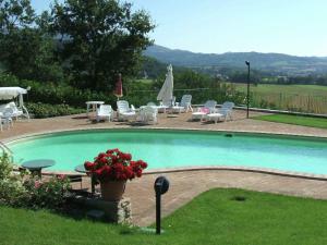 コルチャーノにあるBeautiful Holiday Home in Corciano Umbria with Swimming Poolのスイミングプール(椅子、テーブル、花付)