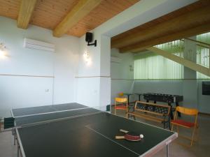 コルチャーノにあるBeautiful Holiday Home in Corciano Umbria with Swimming Poolの卓球台と椅子が備わる客室です。