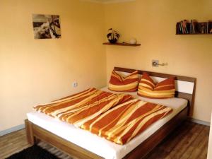 - une chambre dotée d'un lit avec des draps orange et jaune dans l'établissement FERIENBUNGALOW Schwanck in Sagard, à Sagard