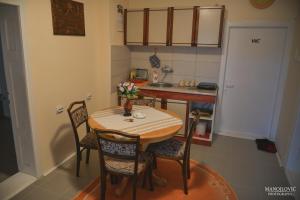 a small kitchen with a table and chairs at Guest House Vila Banjica in Pirot