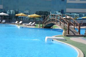 uma grande piscina com uma ponte de madeira sobre ela em The Guard Hotel em Cairo
