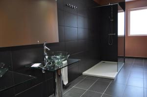 a black bathroom with a sink and a shower at Hotel Indiana in Pinto