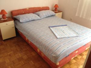 a bed in a bedroom with two night stands and two lamps at Guest House Mareda Palms in Novigrad Istria