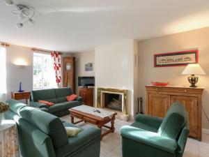 a living room with green couches and a fireplace at Holiday home with pretty terrace and garden, near the Paimpont forest in Lanrelas