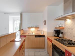 a kitchen with a sink and a stove top oven at Holiday home with pretty terrace and garden, near the Paimpont forest in Lanrelas