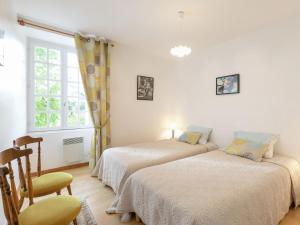 two beds in a room with a chair and a window at Elegant Escape in Lanrelas in Lanrelas