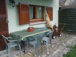 ein Tisch mit Stühlen und ein Tischtuch auf einer Terrasse in der Unterkunft Au Bon Logis in Thannenkirch