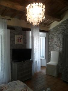 a living room with a television and a chandelier at Fra Bosco e Cielo B&B in Mercato Saraceno