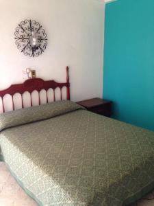 1 dormitorio con 1 cama y reloj en la pared en Hotel Flamingos Colima, en Colima