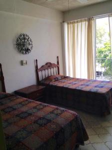 1 dormitorio con 2 camas y ventana en Hotel Flamingos Colima, en Colima