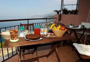 文蒂米利亞的住宿－B&Bilfortesulmare，阳台上的桌子上摆放着食物和水果