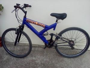 una bici blu è parcheggiata contro un muro di Hotel Rizzi a Encantado