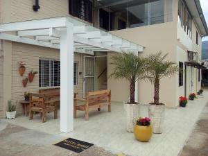un pergolato bianco sul lato di una casa di Hotel Rizzi a Encantado