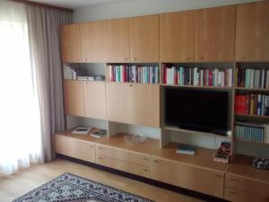 a living room with a tv and book shelves at Ferienwohnung Halder, Ihr Bett im Allgäu in Bad Hindelang