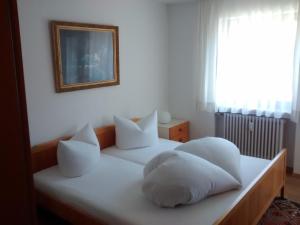 a bedroom with two beds with white pillows and a window at Ferienwohnung Halder, Ihr Bett im Allgäu in Bad Hindelang