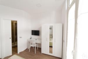 ナポリにあるトレド 116の白い部屋で、デスク、テレビ、鏡が備わります。 +12枚の写真