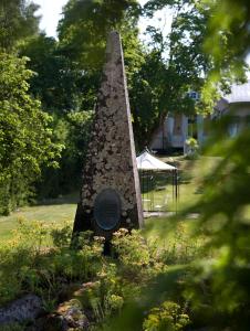 a stone monument in the middle of a yard at Hotel Töyrylä Manor in Artjärvi