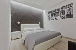 ローマにあるNew Rome house 2の白いベッドルーム(ベッド1台付)と壁に絵が飾られています。