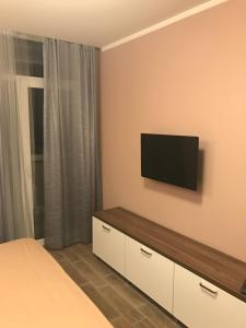 um quarto com uma televisão de ecrã plano na parede em Orbi Residence Apartment em Batumi
