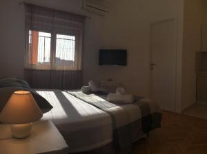 une chambre avec un lit avec une lampe et une fenêtre dans l'établissement Apartment Nina, à Zadar