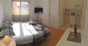 une chambre avec un grand lit et une cuisine dans l'établissement Apartment Nina, à Zadar