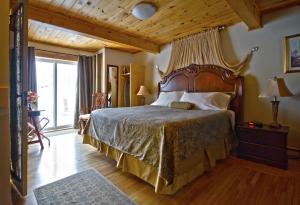 a bedroom with a large bed with a wooden headboard at Mackenzie Motel & Cottages in Shelburne