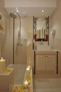 a bathroom with a sink and a mirror and candles at Villa Isabella in Naousa