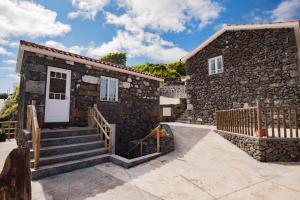 Calheta de NesquimにあるStone Dreams - Namoradeiraの白いドアと階段の石造りの家