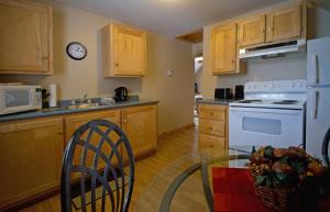 a kitchen with a table and a white stove top oven at Mackenzie Motel & Cottages in Shelburne