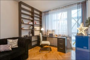 ワルシャワにあるP&O Apartments Metro Nowy Swiatのリビングルーム(ソファ、デスク、椅子付)