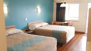 a hotel room with two beds and a table at Motel 6 Albany, OR in Albany