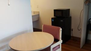 a room with a table and a microwave and a tv at Motel 6 Albany, OR in Albany