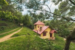 a small house on the side of a dirt road at The Seven Sisters Farm in Kodaikānāl