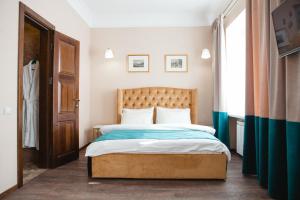 a bedroom with a large bed with a wooden headboard at Live.Here.Hotel in Kyiv