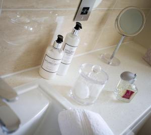 a bathroom sink with two bottles of soap and a mirror at The Old Manor House in Halford