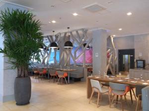 a dining room with tables and chairs and plants at Novotel RJ Porto Atlantico in Rio de Janeiro