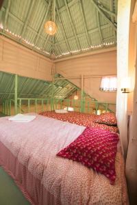 a large room with a large bed with a pink blanket at The Seven Sisters Farm in Kodaikānāl