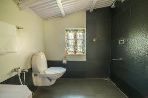 a bathroom with a white toilet and a shower at The Seven Sisters Farm in Kodaikānāl