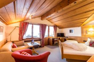 ein Hotelzimmer mit einem Bett und einem Wohnzimmer in der Unterkunft Hotel Bergruh in Oberstdorf
