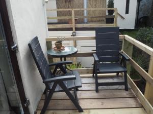 dwa krzesła i stół na balkonie w obiekcie The Smugglers w mieście Penzance
