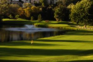 a golf course with a pond and a fountain at San Vicente Golf Resort in Ramona