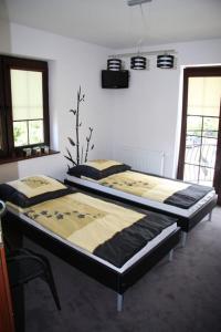 two beds in a room with two windows at Villa Farage in Mielno