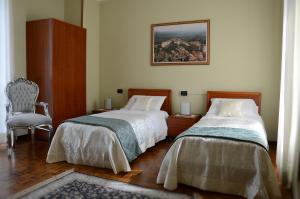 een slaapkamer met 2 bedden en een stoel bij Hotel La Fenice in Chiari