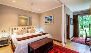 a bedroom with a bed and a large window at Khaya Ndlovu Safari Manor in Hoedspruit