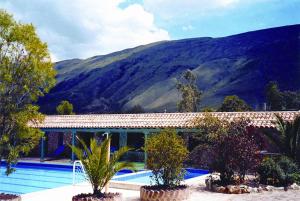 une maison avec piscine avec des montagnes en arrière-plan dans l'établissement Hotel Boutique Iguaque Campestre Spa & Ecolodge, à Villa de Leyva