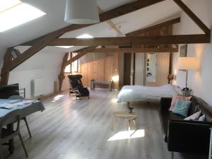 ein Wohnzimmer mit einem Bett und einem Sofa in der Unterkunft La Chicorée in Annoeullin