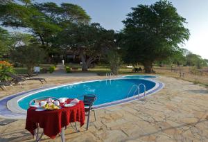 a table and chairs next to a swimming pool at Ashnil Aruba Lodge in Aruba Lodge