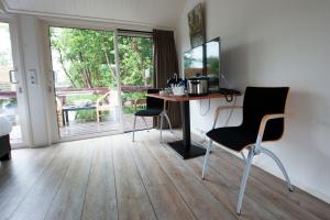 um quarto com uma secretária, um computador e cadeiras em De Dames Van De Jonge Hotel Restaurant em Giethoorn