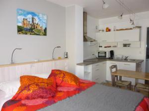 a bedroom with a bed and a small kitchen at Aux Blanches Pierres in Fumel